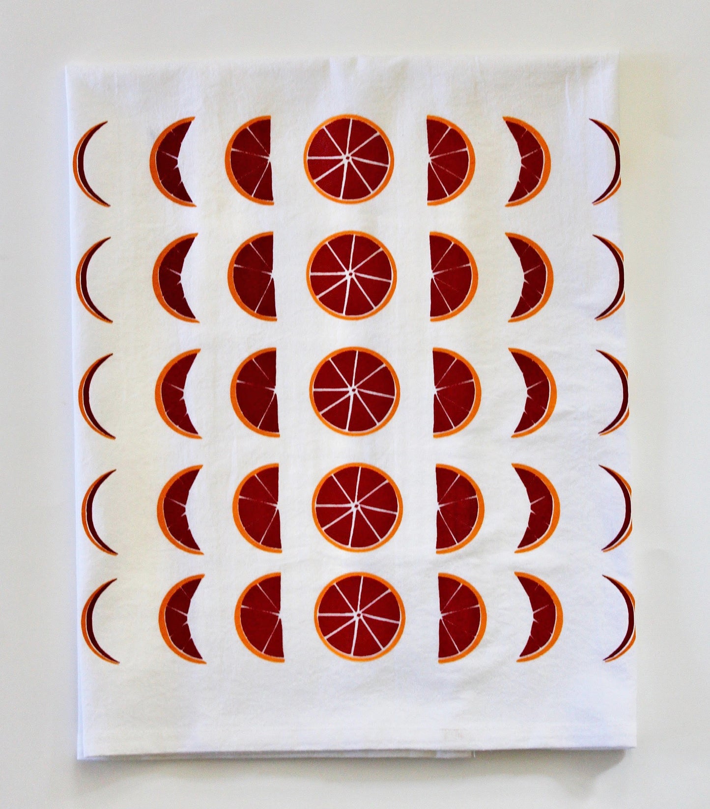 White tea towel with red and orange blood orange moon phases design
