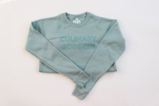 Dusty blue crewneck sweatshirt with teal block lettering that says "Culinary Goddess"