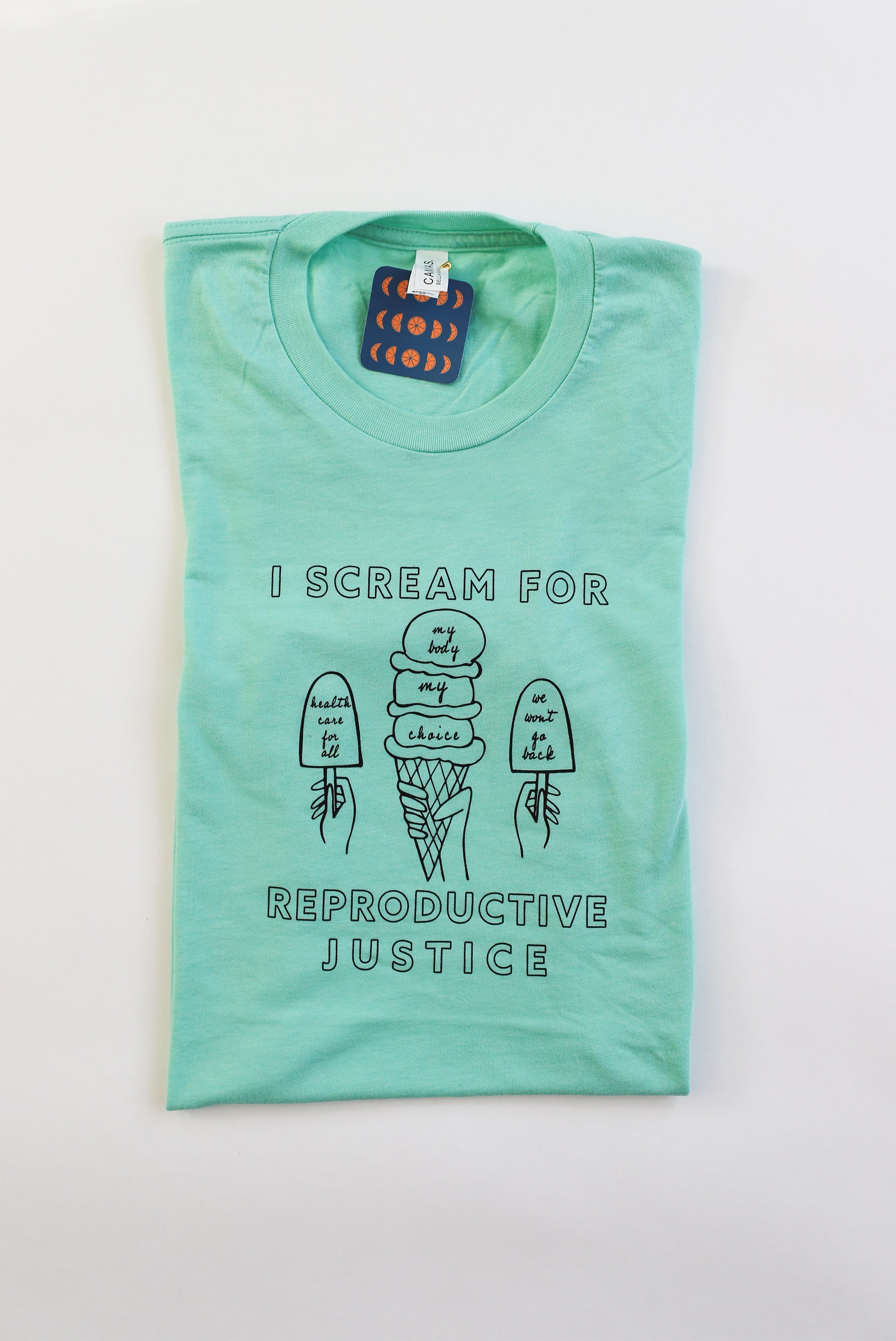 A folded mint green tea with black letters that read I Scream for Reproductive Justice and ice cream designs