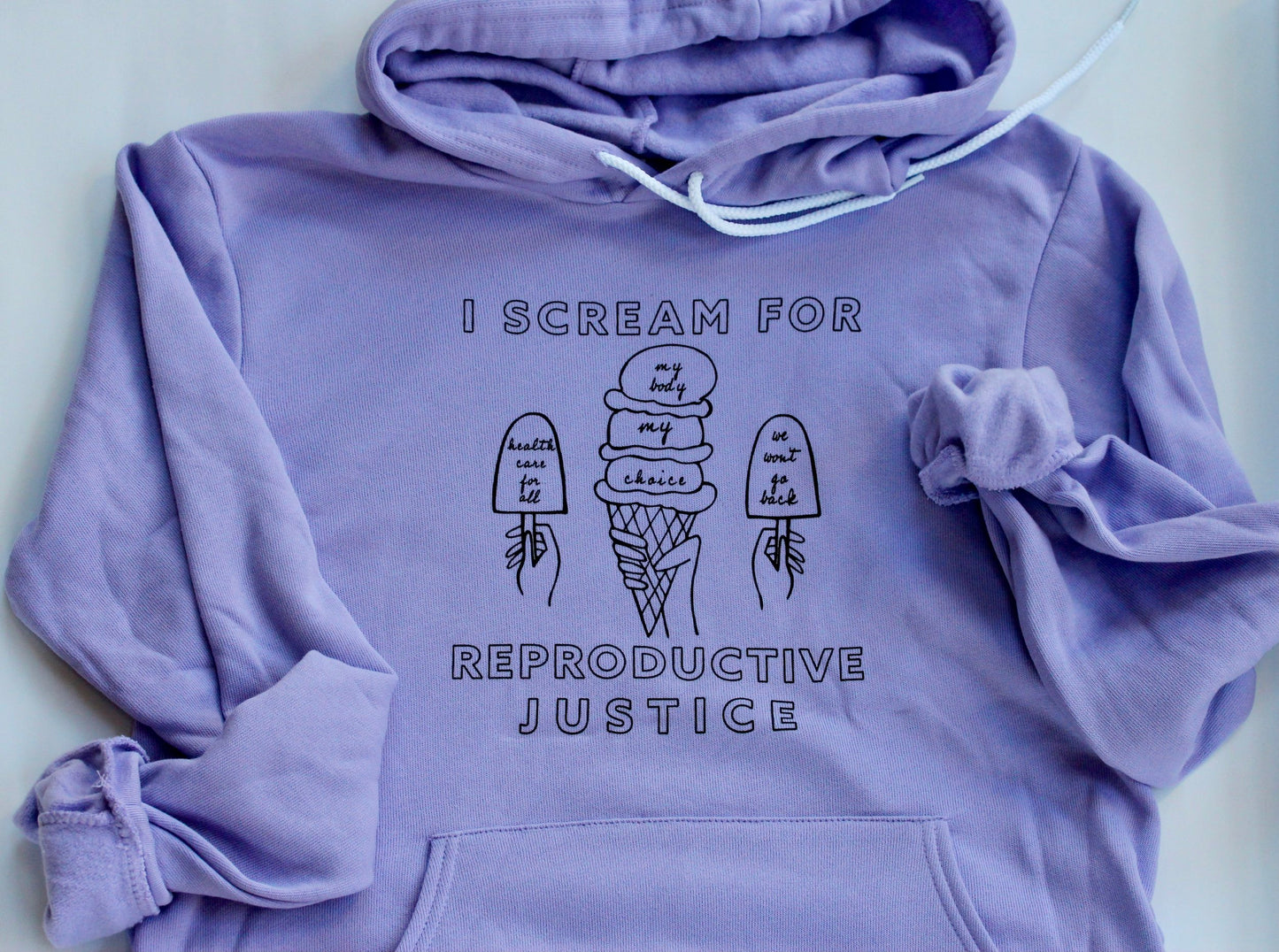 A lavender hoodie with the words I Scream for Reproductive Justice in black block letters with ice cream illustrations
