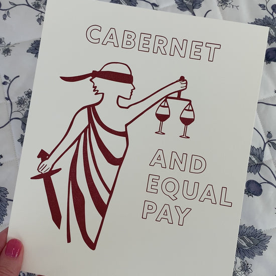 An art print with the image of Lady Justice and the words "Cabernet and Equal Pay"