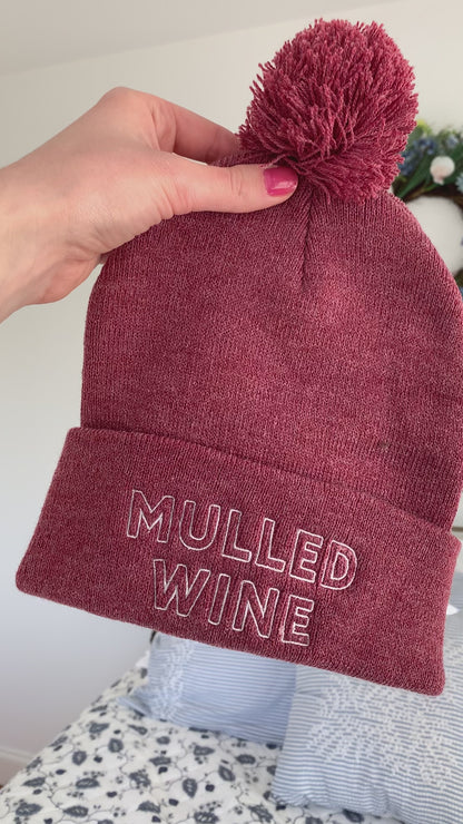 A heather wine colored beanie reads "Mulled Wine" in white embroidery