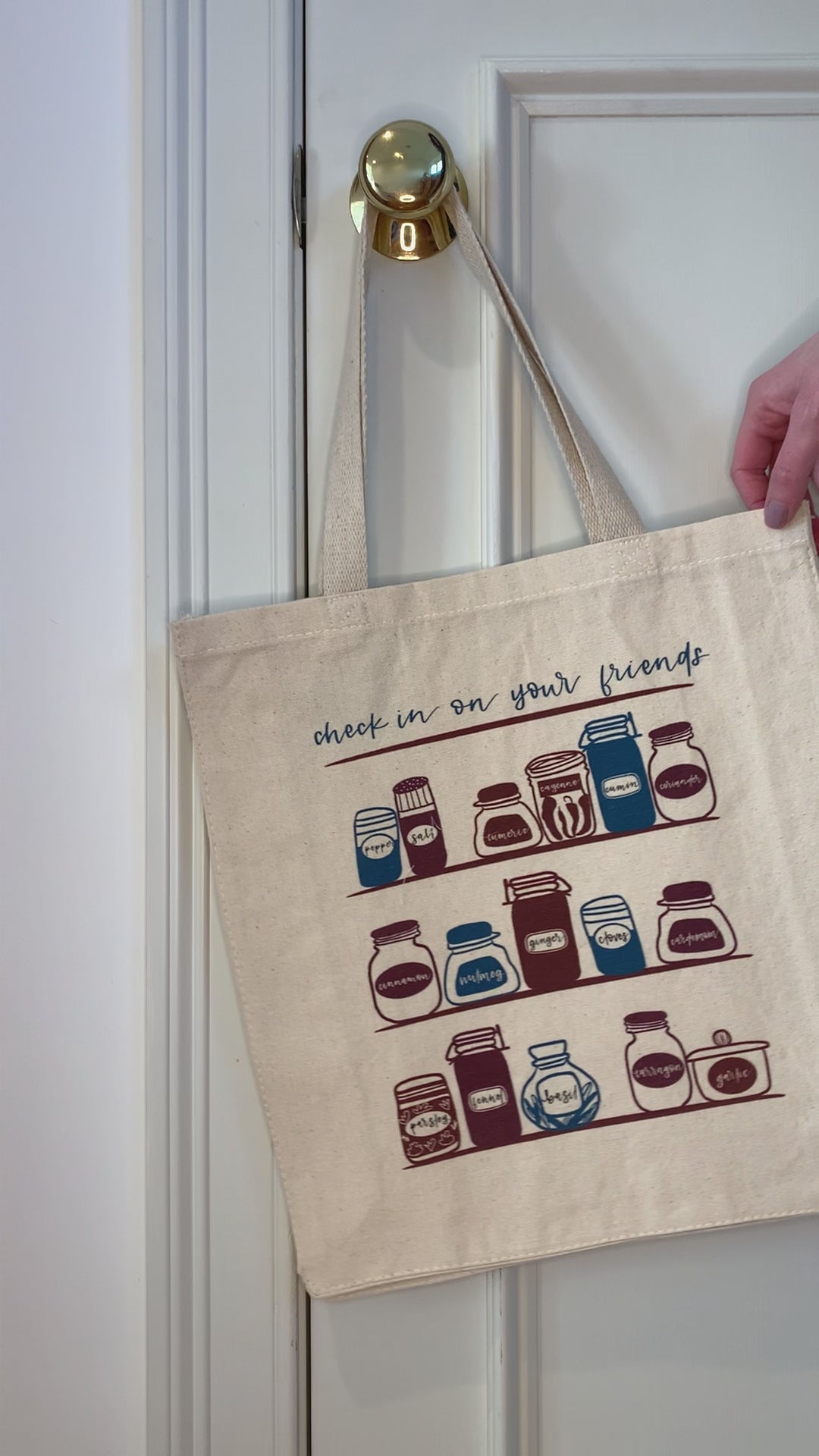 A canvas tote that reads "Check in on Your Friends" hangs from a doorknob