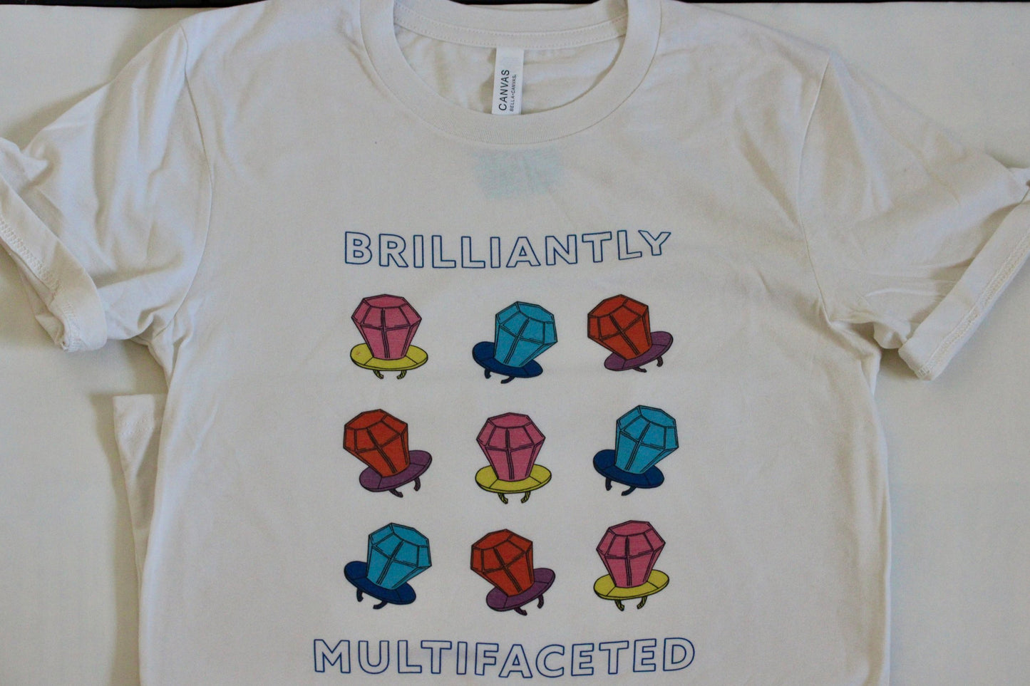 Cute t-shirt with colorful design and the words "Brilliantly Multifaceted"