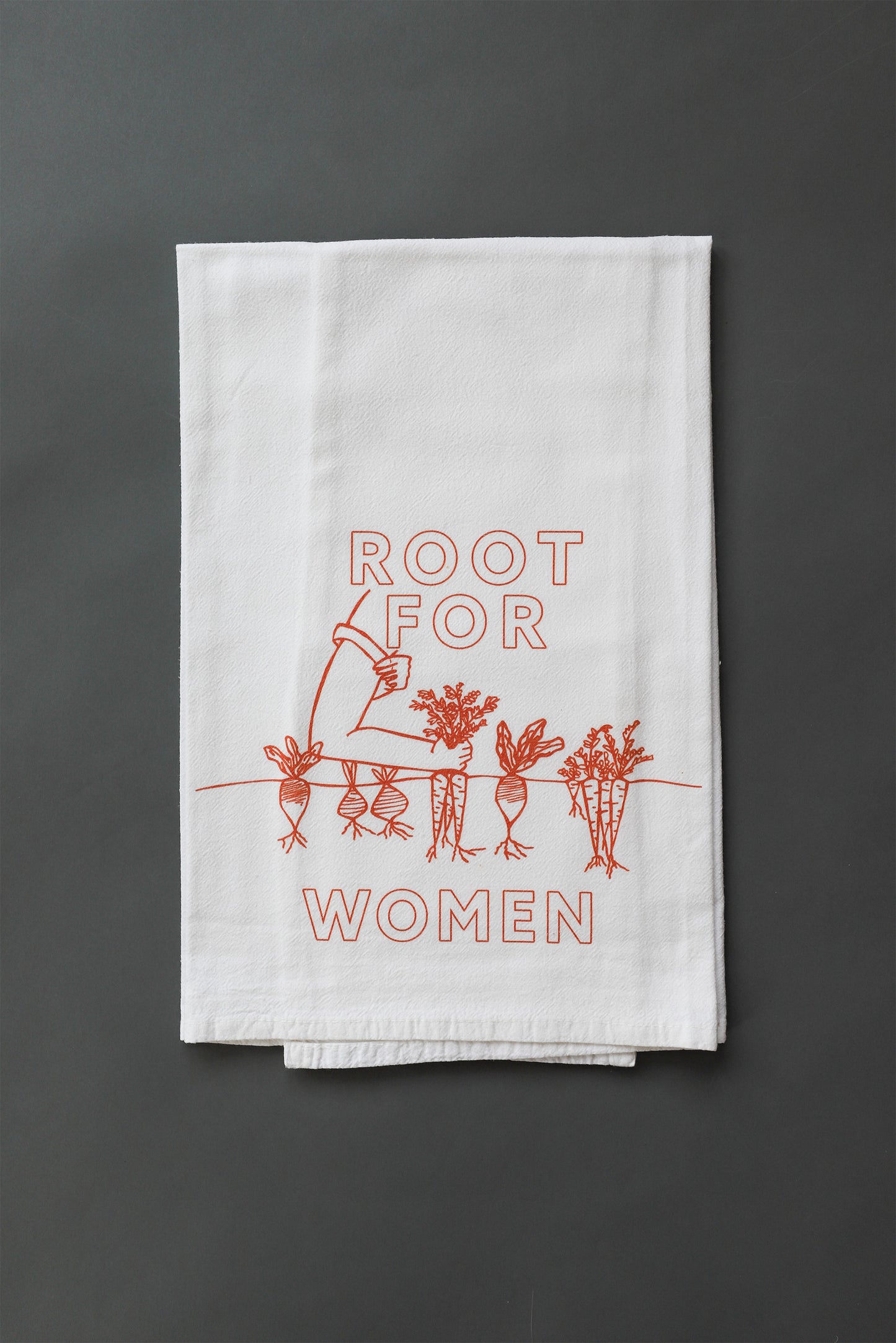 A white tea towel with red block letters that read "Root for Woman" and a garden illustration 
