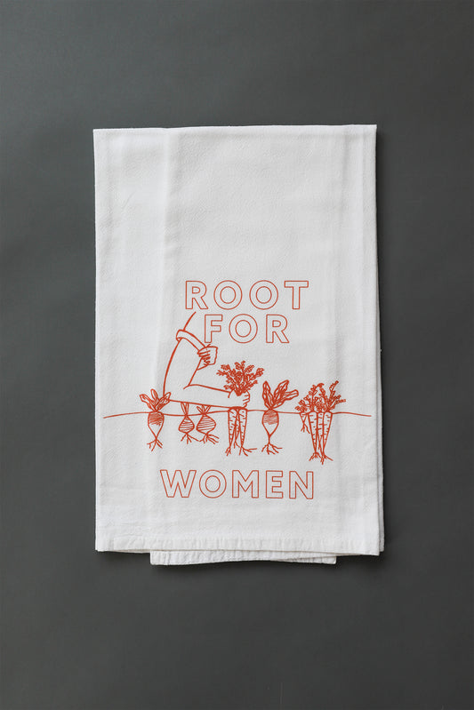 A white tea towel with red block letters that read "Root for Woman" and a garden illustration 