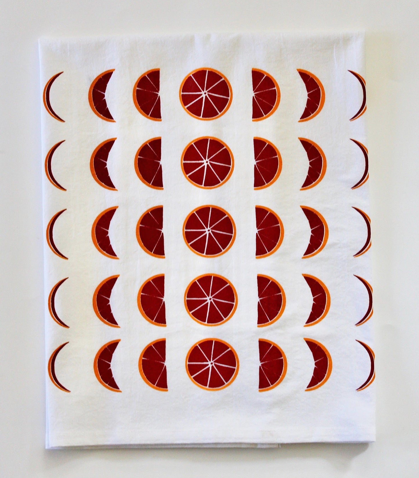 White tea towel with blood orange moon phase illustration