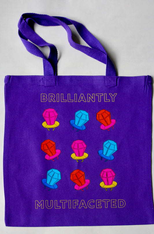Purple tote bag with "Brilliantly Multifaceted" and candy design
