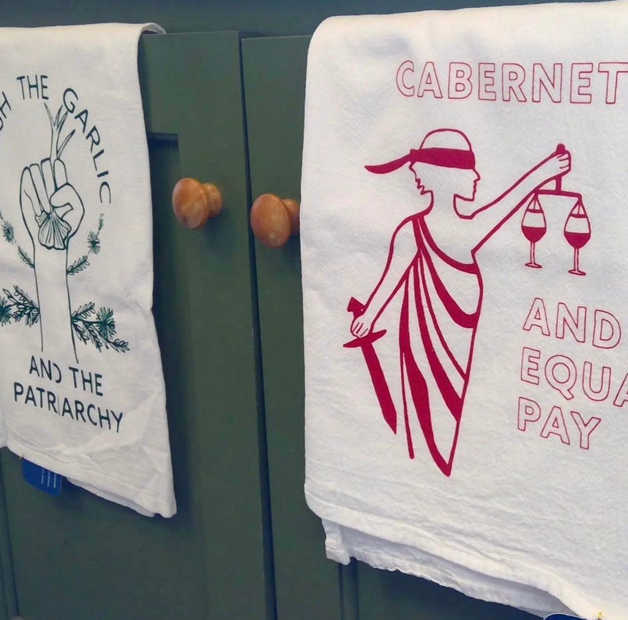 Two tea towels hanging in a kitchen