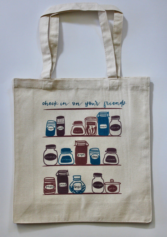Canvas tote with the words "Check in on your friends" and image of kitchen shelves