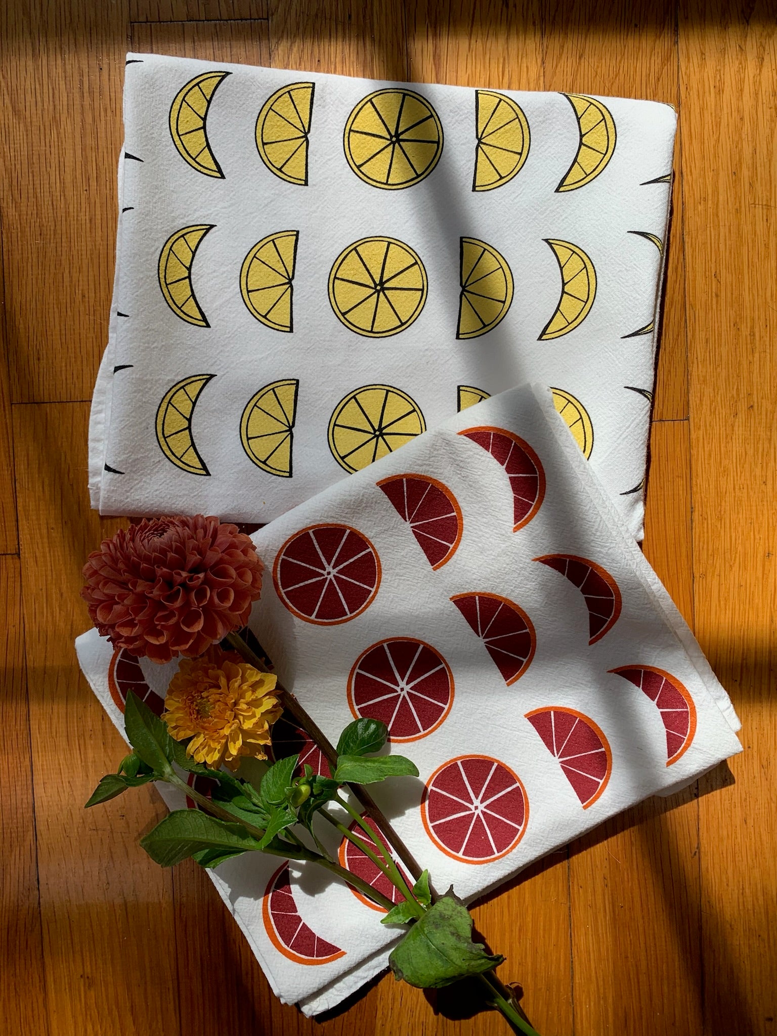 Two tea towels with different citrus moon phase designs