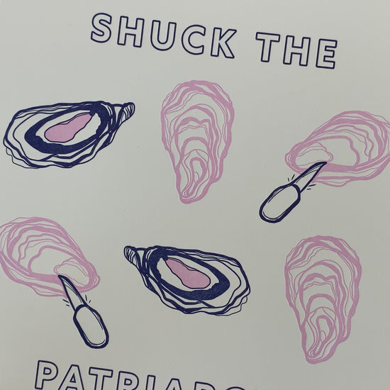 A woman holds an art print that reads "Shuck the Patriarchy" with oyster illustrations 