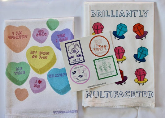 A tea towel with candy hearts, a tea towel with ring pops and the words Brilliantly Multifaceted, and 4 stickers