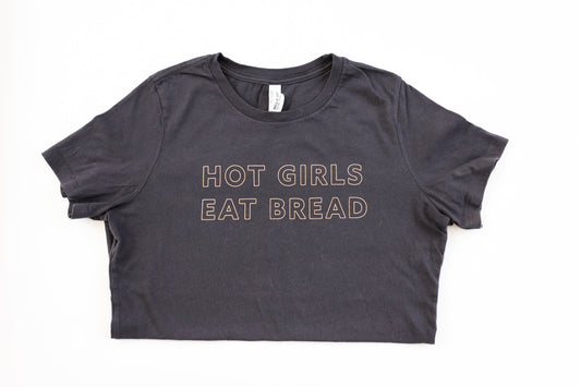 A dark grey women's tee with "Hot Girls Eat Bread" in block letters