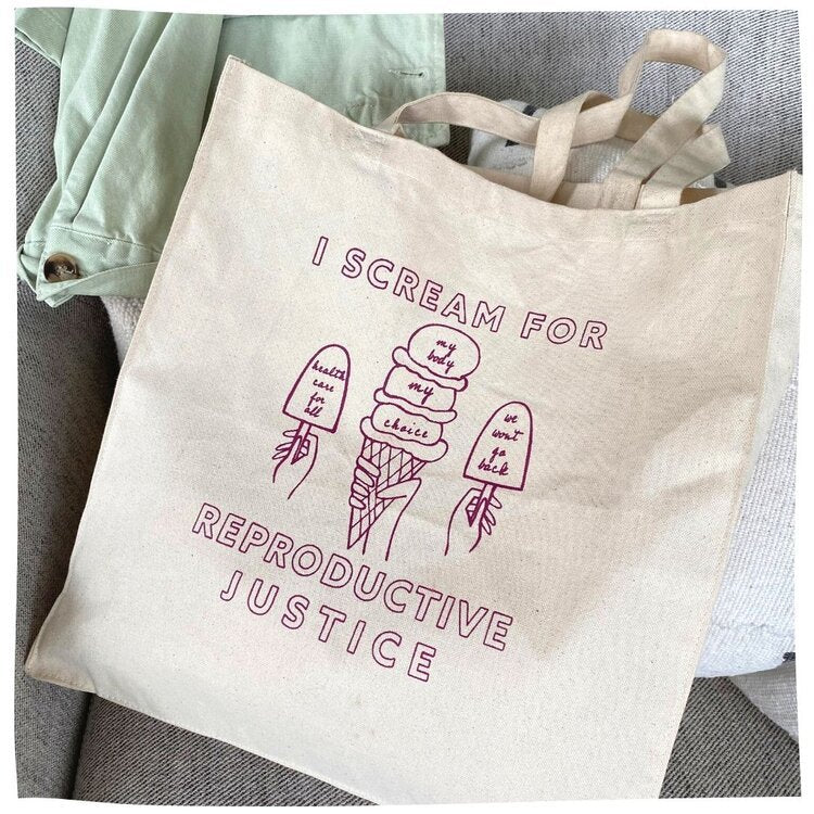 A canvas tote with the words I Scream for Reproductive Justice and ice cream illustrations in a raspberry color