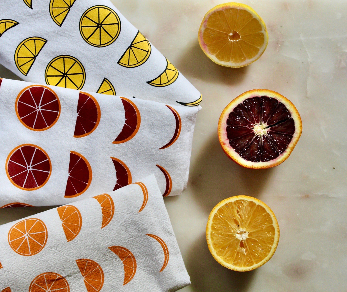 A tea towel trio with lemon, orange and blood orange moon phase designs
