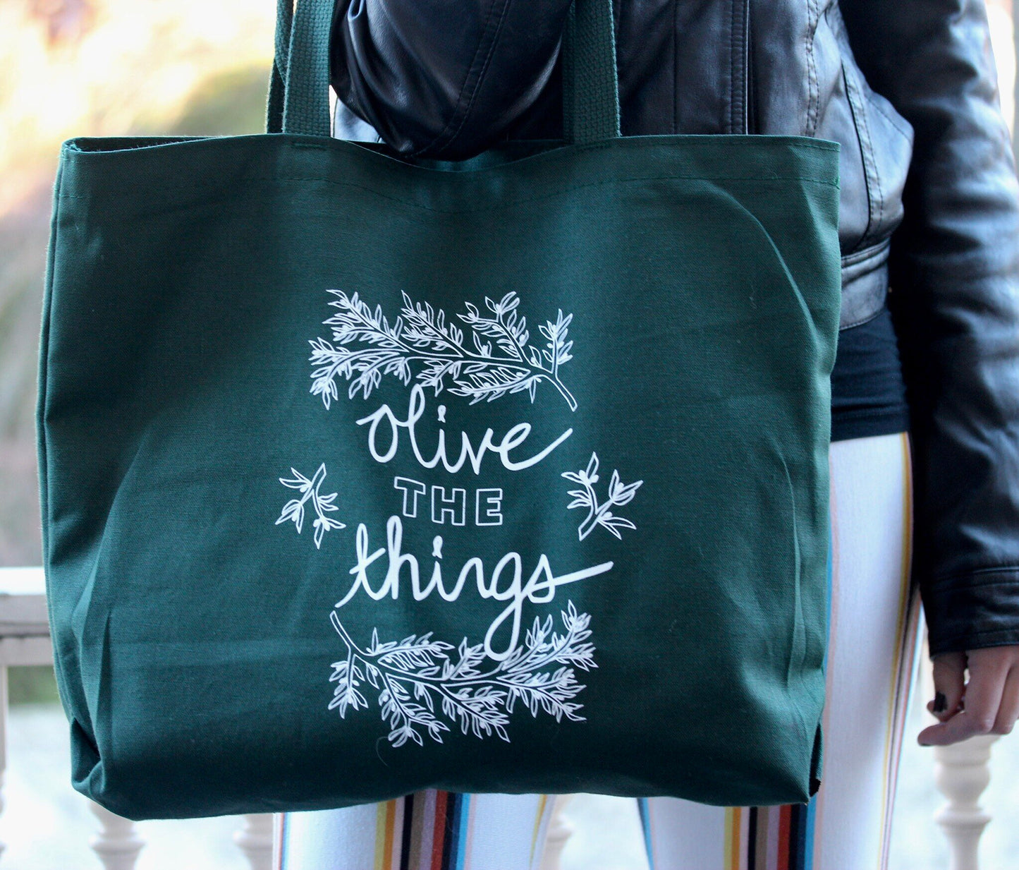 An extra large green canvas tote with the words "Olive the things" and olive branch designs