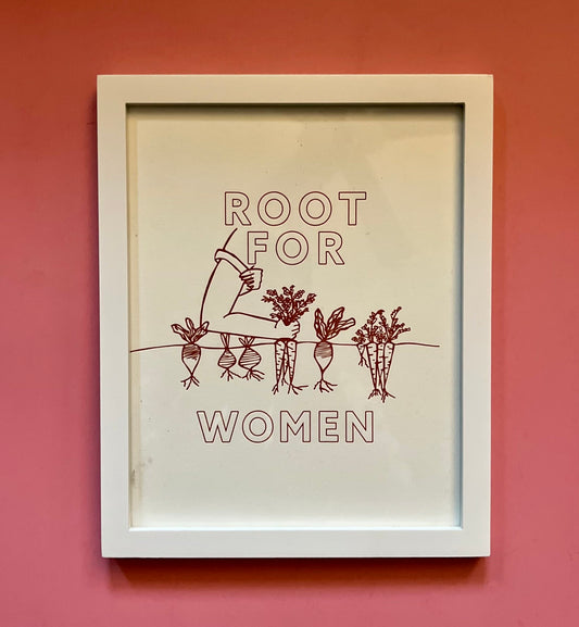 A framed art print reads "Root for women" in block letters with a garden illustration