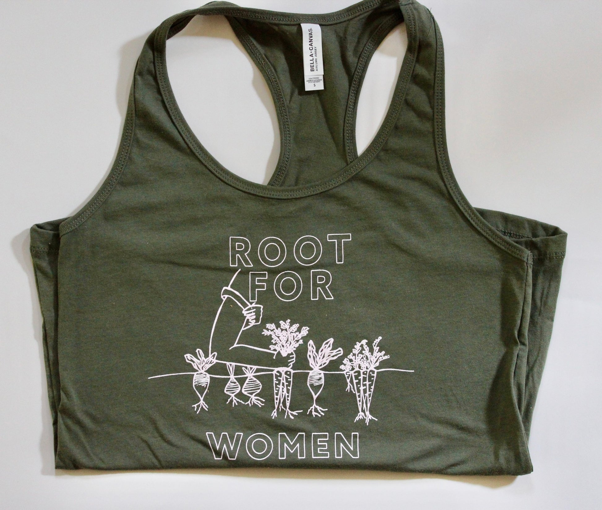 A folded olive green tank with block letters that read "Root for Women" and a garden illustration