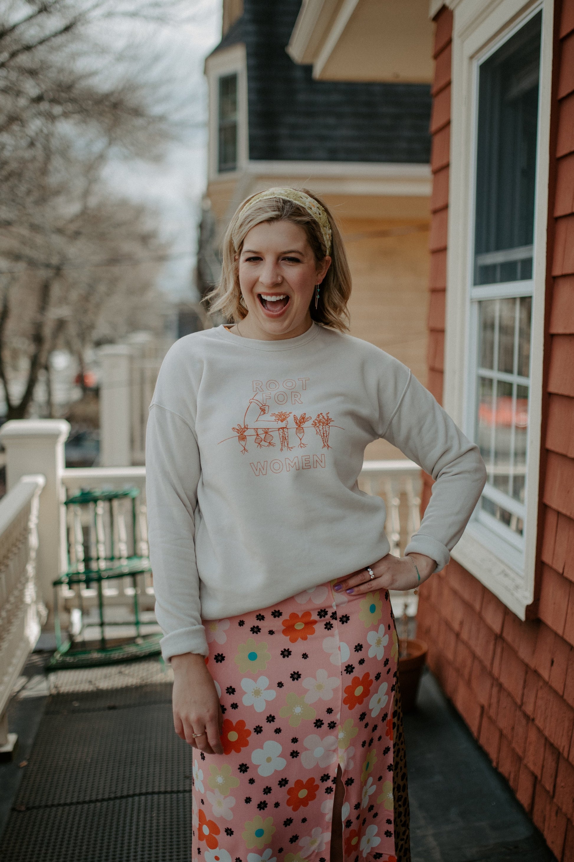  A woman wears a natural color Root for Women crewneck with a flowered skirt