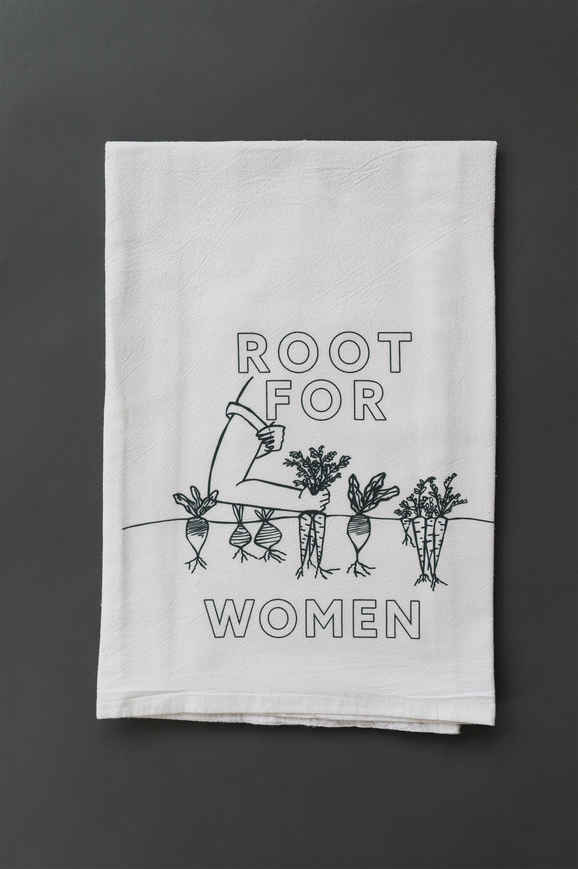 A white tea towel with green block letters that read "Root for Women" with a garden illustration 
