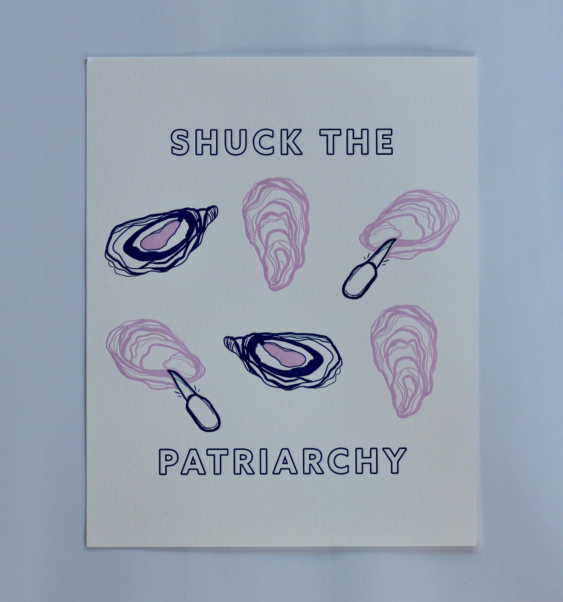 An art print reads "Shuck the Patriarchy" in block letters with oyster illustrations 