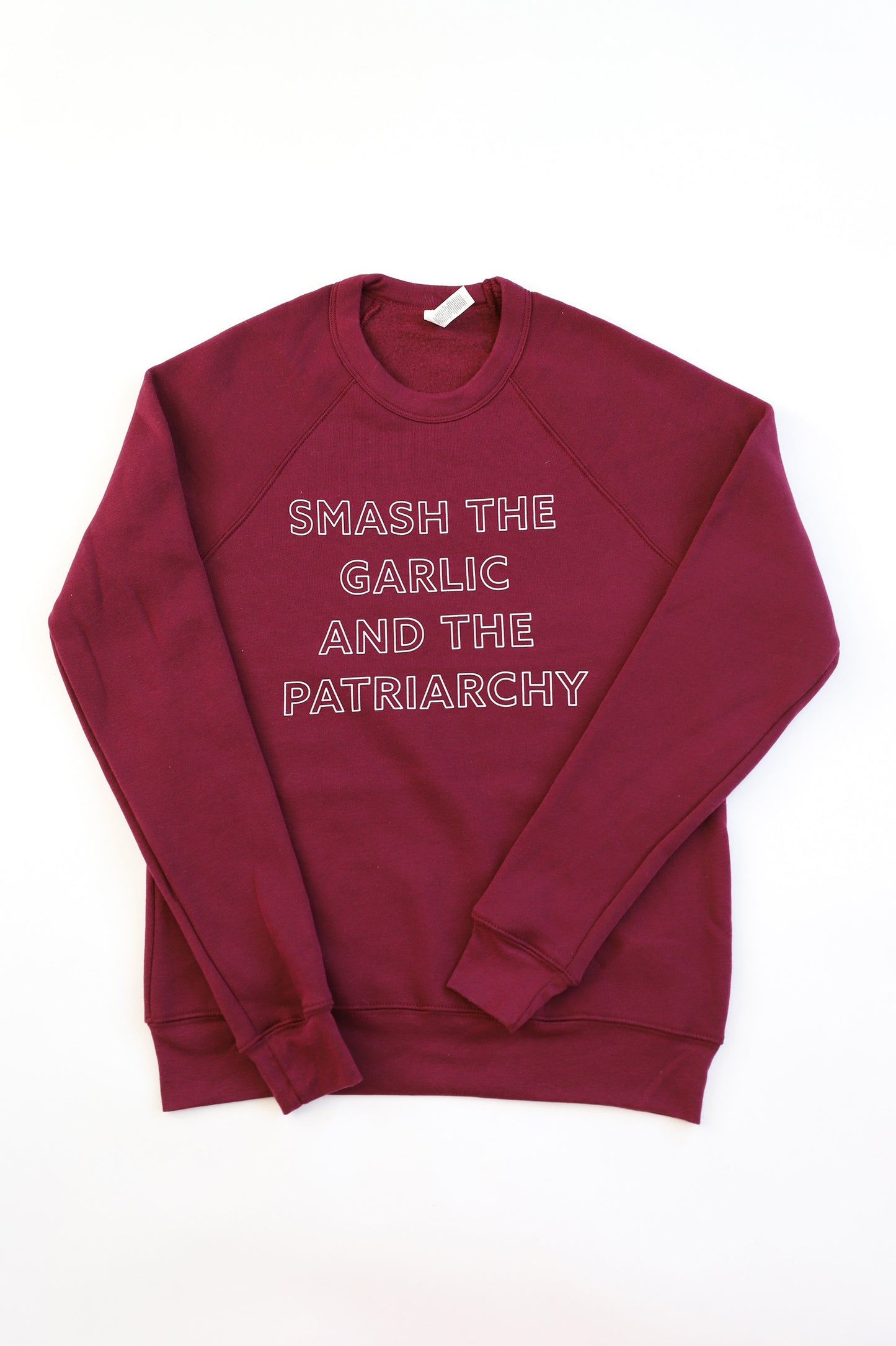 A maroon crewneck sweatshirt reads "Smash the Garlic and the Patriarchy" in block letters
